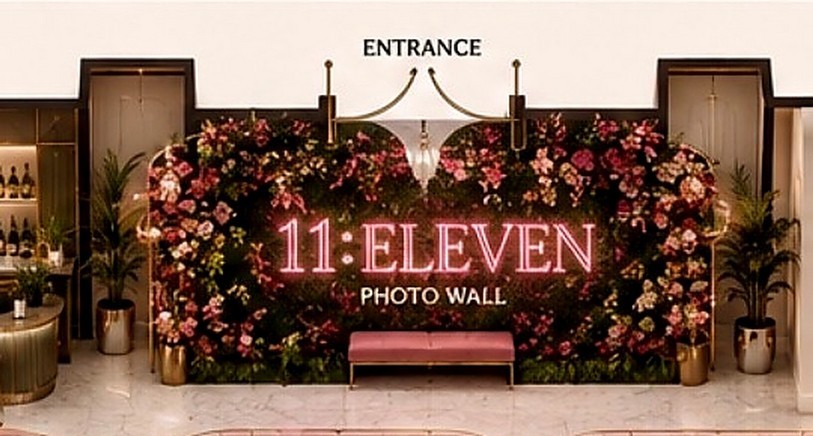 The 11:Eleven entrance photo wall — a floral installation framing the neon 11:Eleven logo